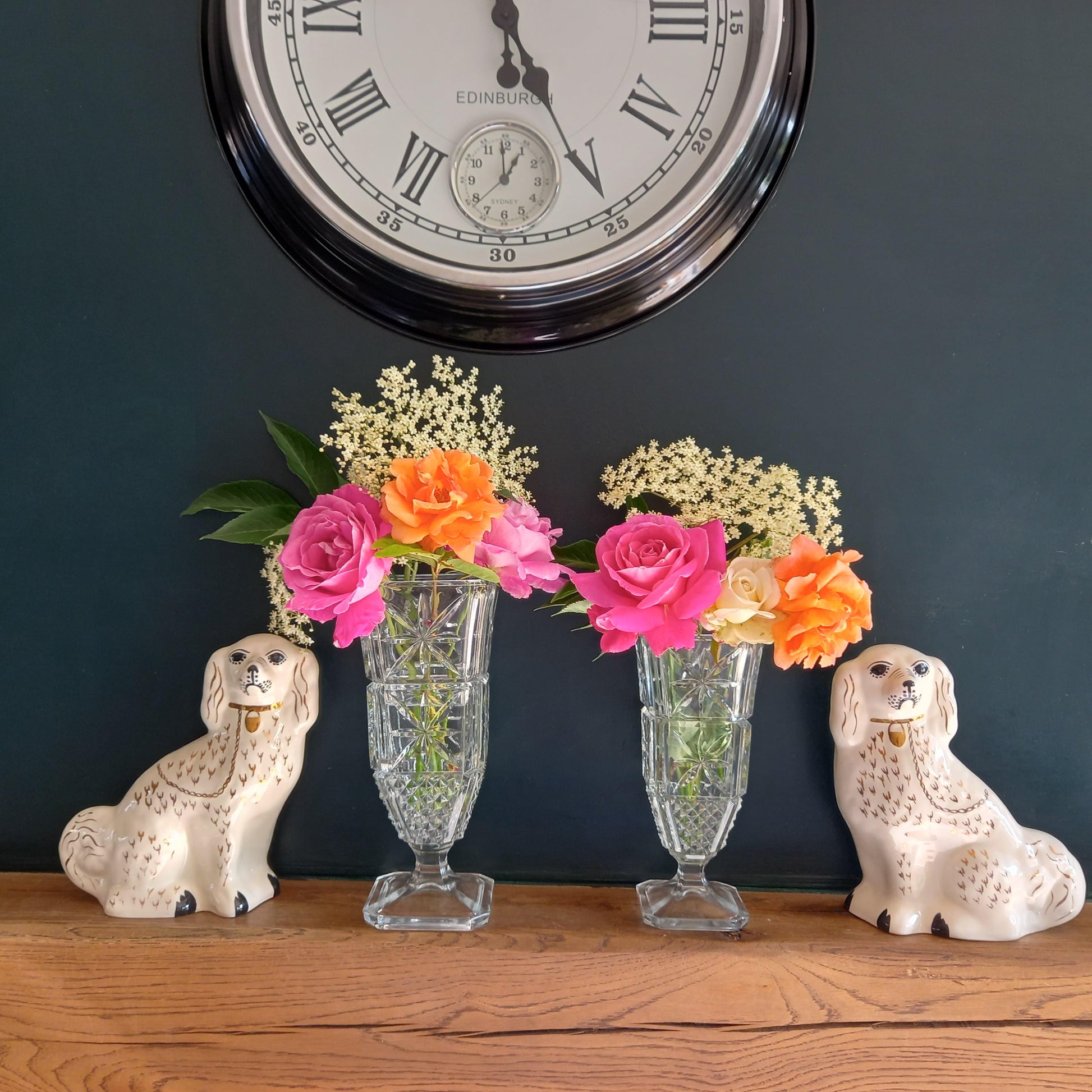Pair of Findenza Vetraria Starburst and Hobnail Italian Glassware Vases styled with Mantle dogs and flowers on a wooden mantle